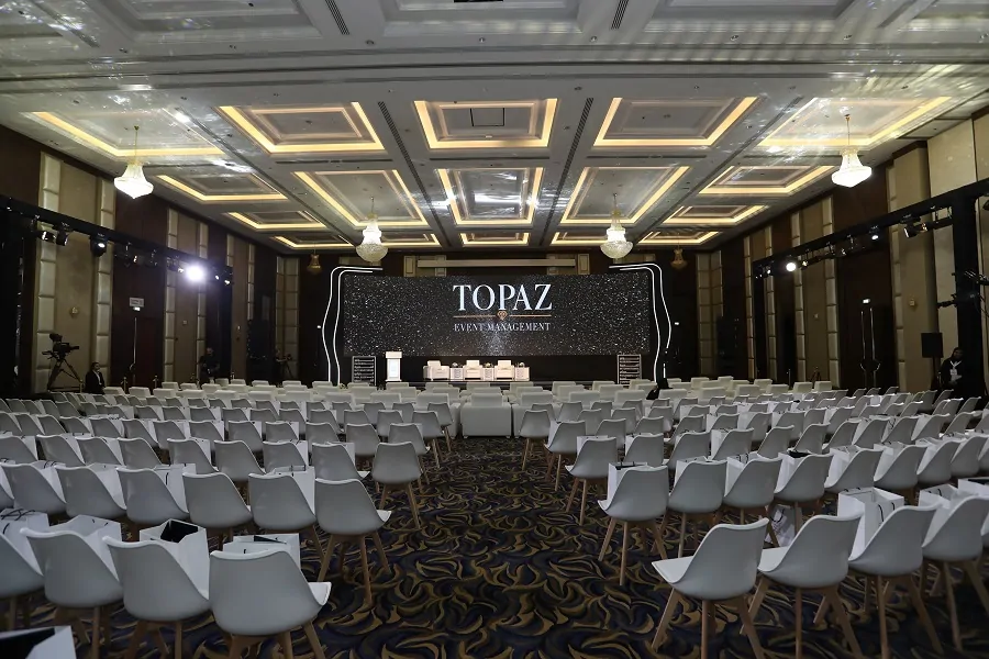 Conference hall with stage, branded screen and white seating at the Fujairah International Philosophy Conference 2022
