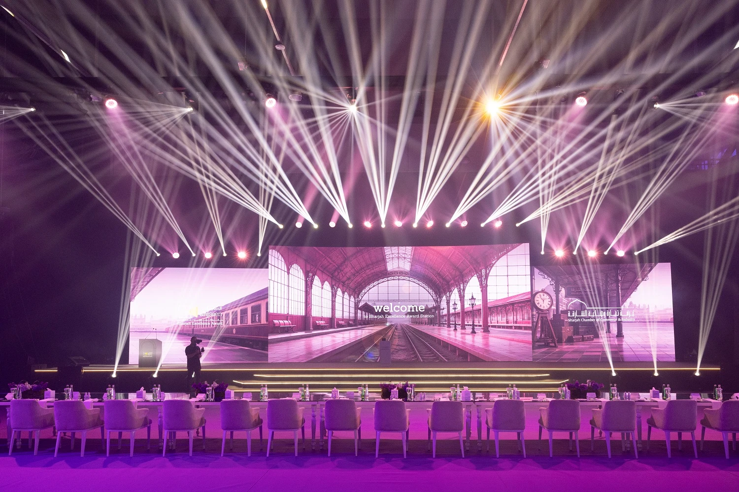 Beam lights sweeping over the stage and railway-station LED backdrop at Shjseen 2026, Expo Centre Sharjah