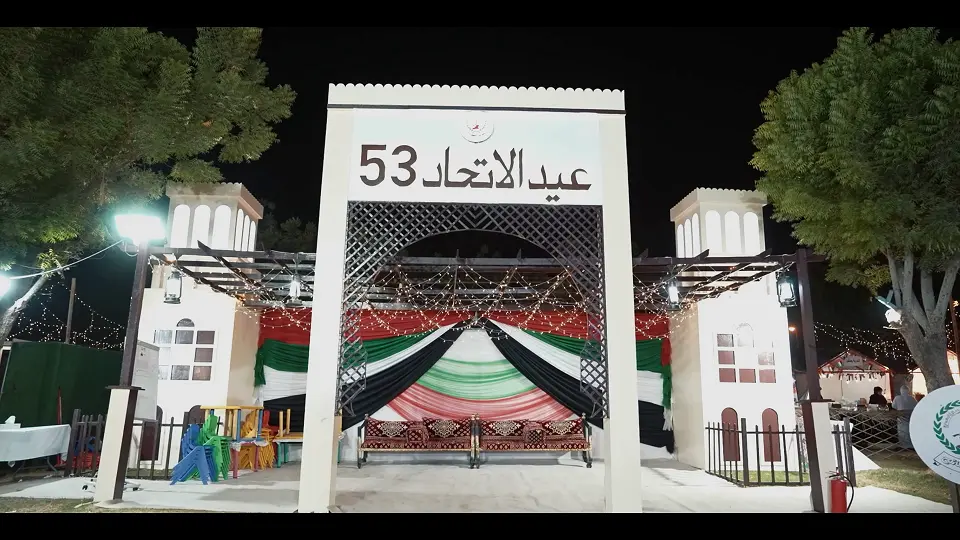 Heritage-style Eid Al Etihad 53 gate with flag-coloured drapes and majlis seating at Sharjah National Park