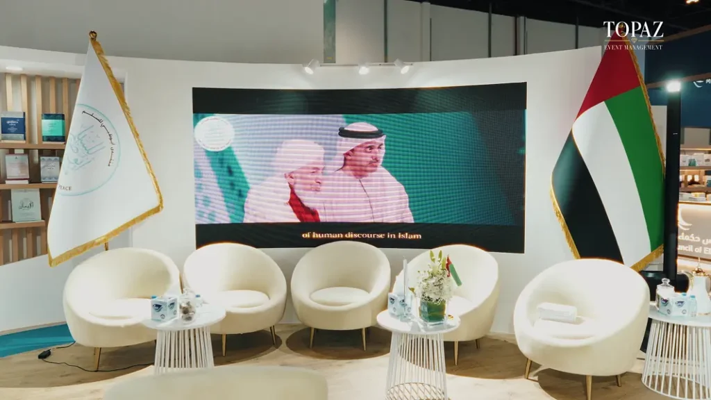 Lounge seating, LED screen and UAE flag on the Abu Dhabi Forum for Peace stand, Abu Dhabi International Book Fair