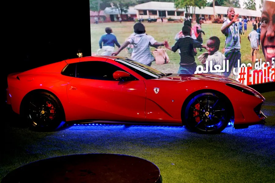 Red Ferrari displayed in front of the campaign LED screen at the Emirates Auction Dubai 2023
