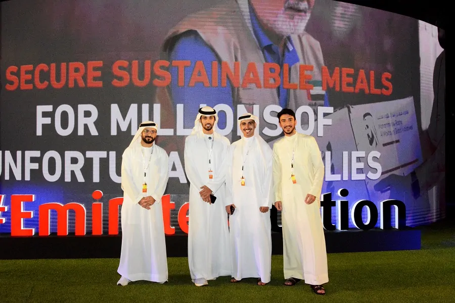 Guests in front of the 1 Billion Meals campaign LED screen at the Emirates Auction charity auction, Dubai 2023