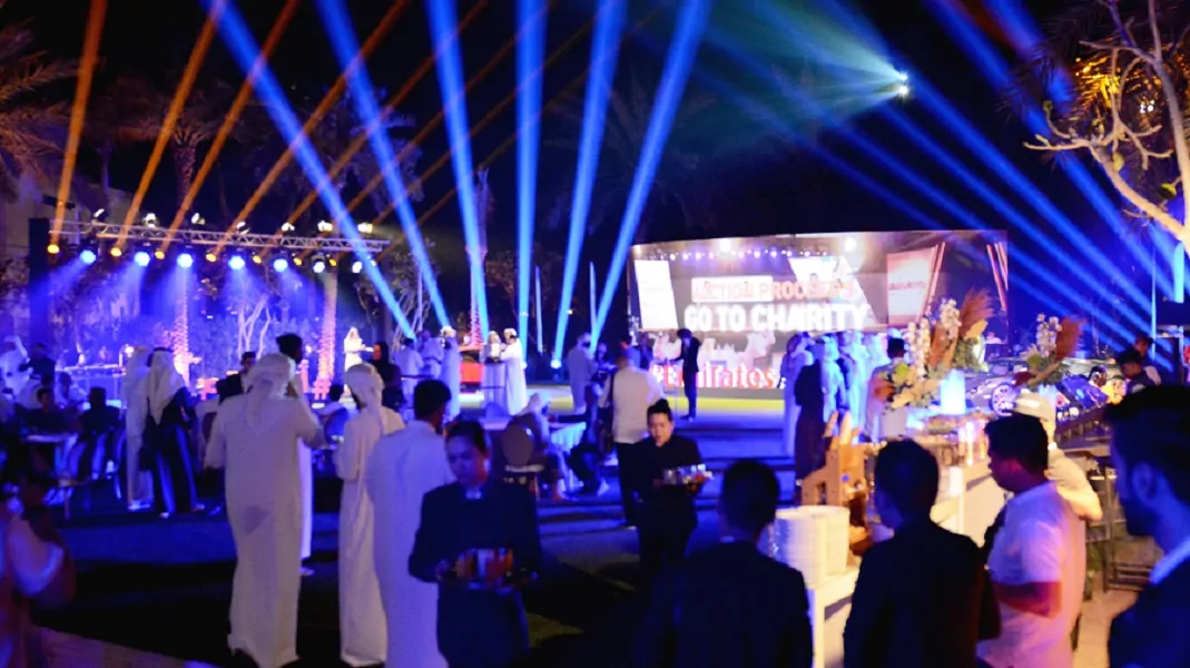 Outdoor auction night with beam lights and LED screen at the Emirates Auction charity event, Dubai 2023