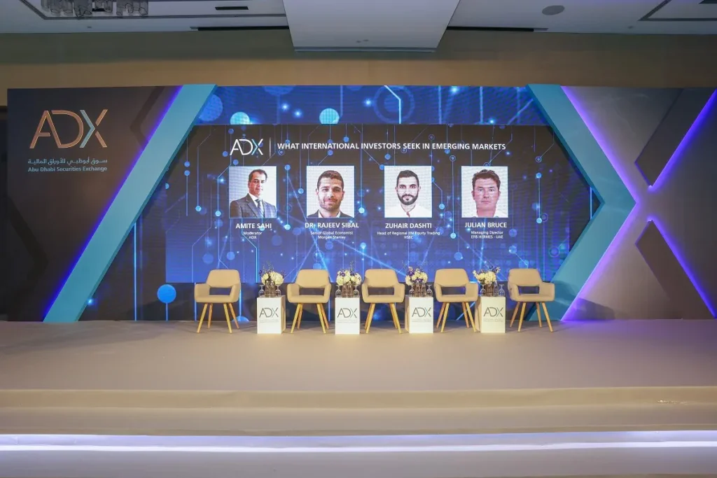 ADX branded conference stage with LED screen and panel seating for the What International Investors Seek in Emerging Markets session, 2024