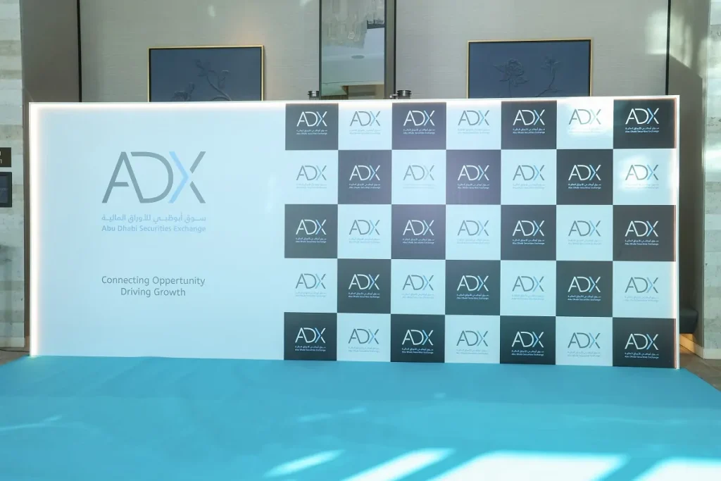Illuminated ADX Abu Dhabi Securities Exchange media wall with Connecting Opportunity Driving Growth message at the ADX Conference 2024