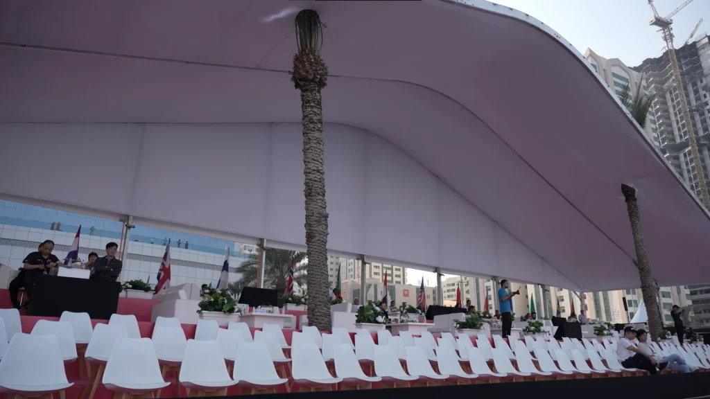 Shaded VIP grandstand with tiered seating, lounge furniture and national flags at the F1H2O Grand Prix of Sharjah 2024