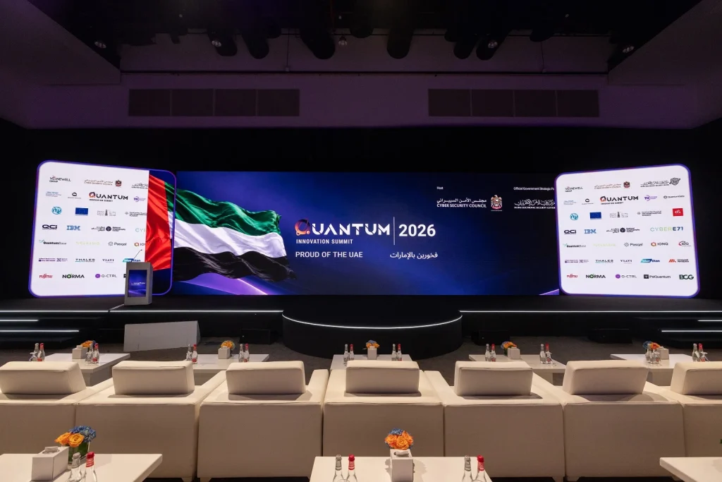 Main summit stage with LED screens showing Quantum 2026 branding, the UAE flag and VIP lounge seating at Grand Hyatt Dubai