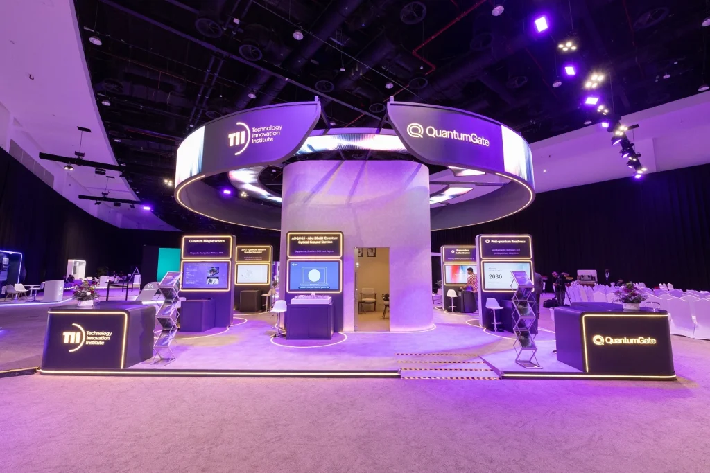 Circular Quantinuum booth with an overhead illuminated ring and interactive screens