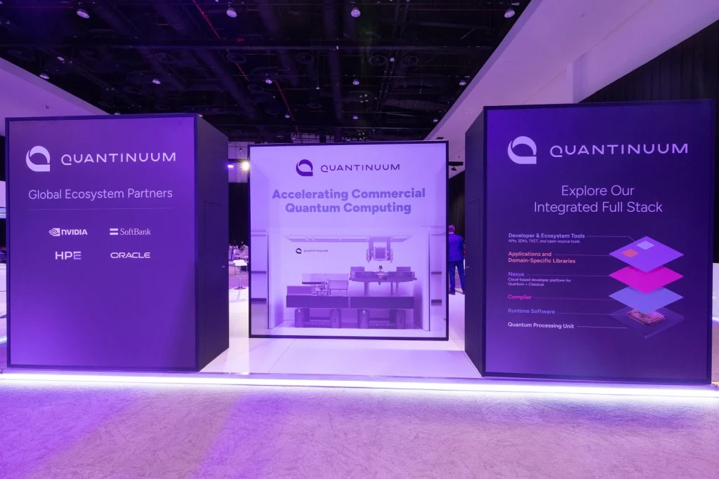 Quantinuum branded booth walls with product graphics and backlit panels