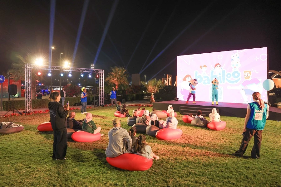 Families watching a kids’ show on the lawn stage at the Shams Creative Festival 2025, Sharjah