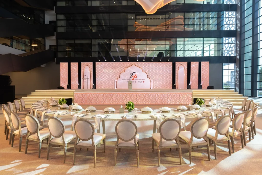 Round tables with white chairs arranged in front of the main stage ahead of the forum