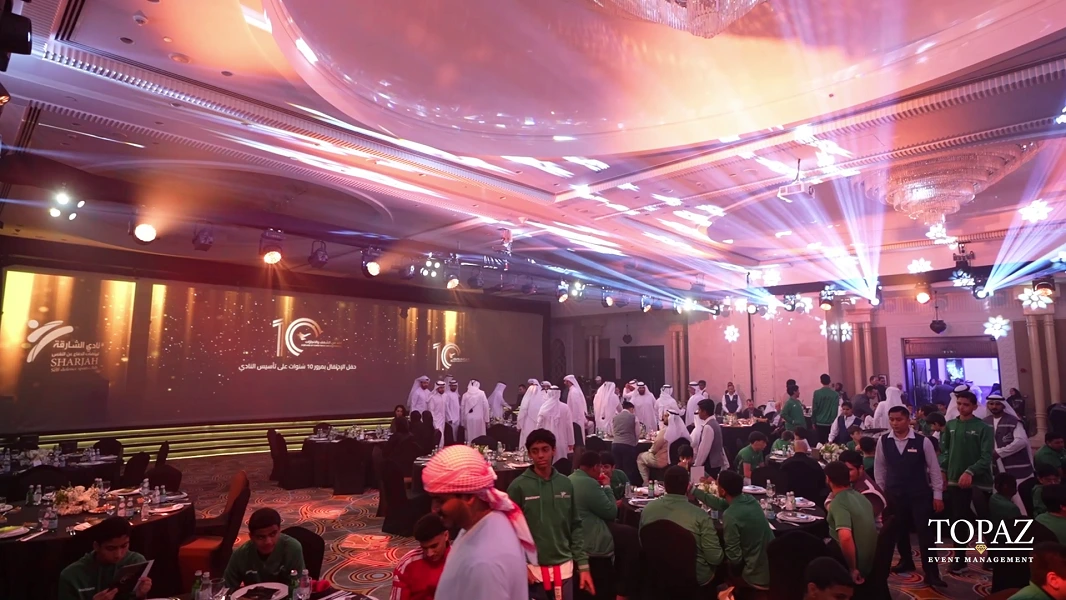 Guests and club members in the ballroom with stage lighting at the Sharjah Self-Defense Sports Club 10th Anniversary Celebration, Sharjah