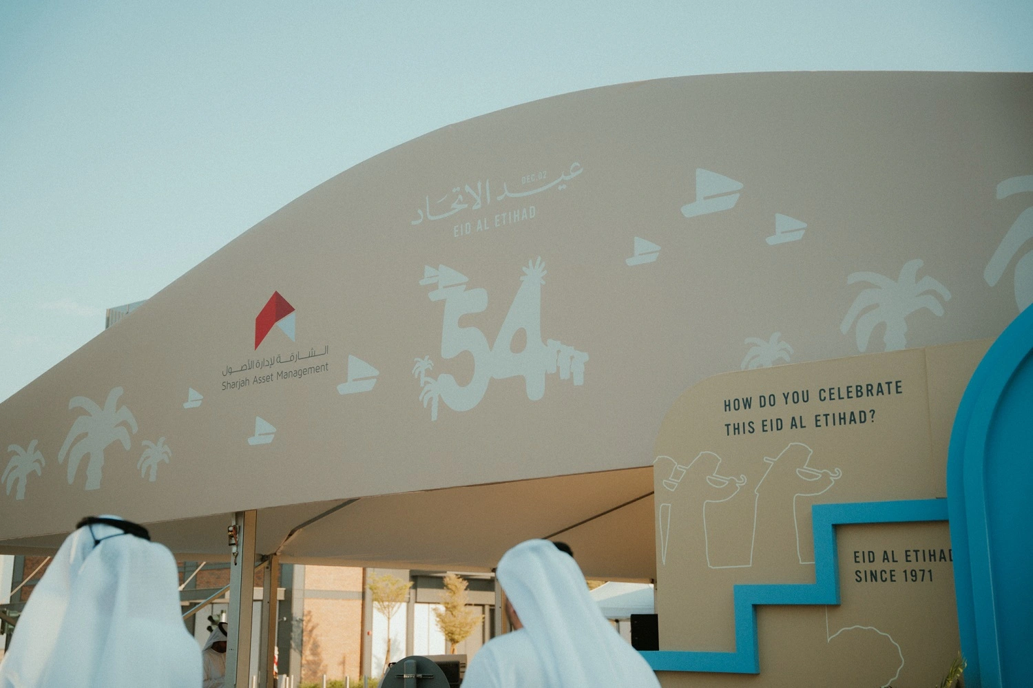 Branded 54th UAE National Day facade with Emirati heritage illustrations at the Sharjah Asset Management celebration