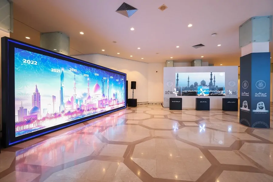 Large LED timeline wall and interactive screens in the foyer at the Abu Dhabi Forum for Peace National Day and Erth Zayed event