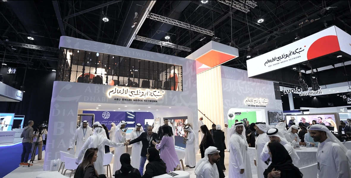 Abu Dhabi Media Network two-storey exhibition booth with branded channel zones and visitors, designed by Topaz Events, 2024
