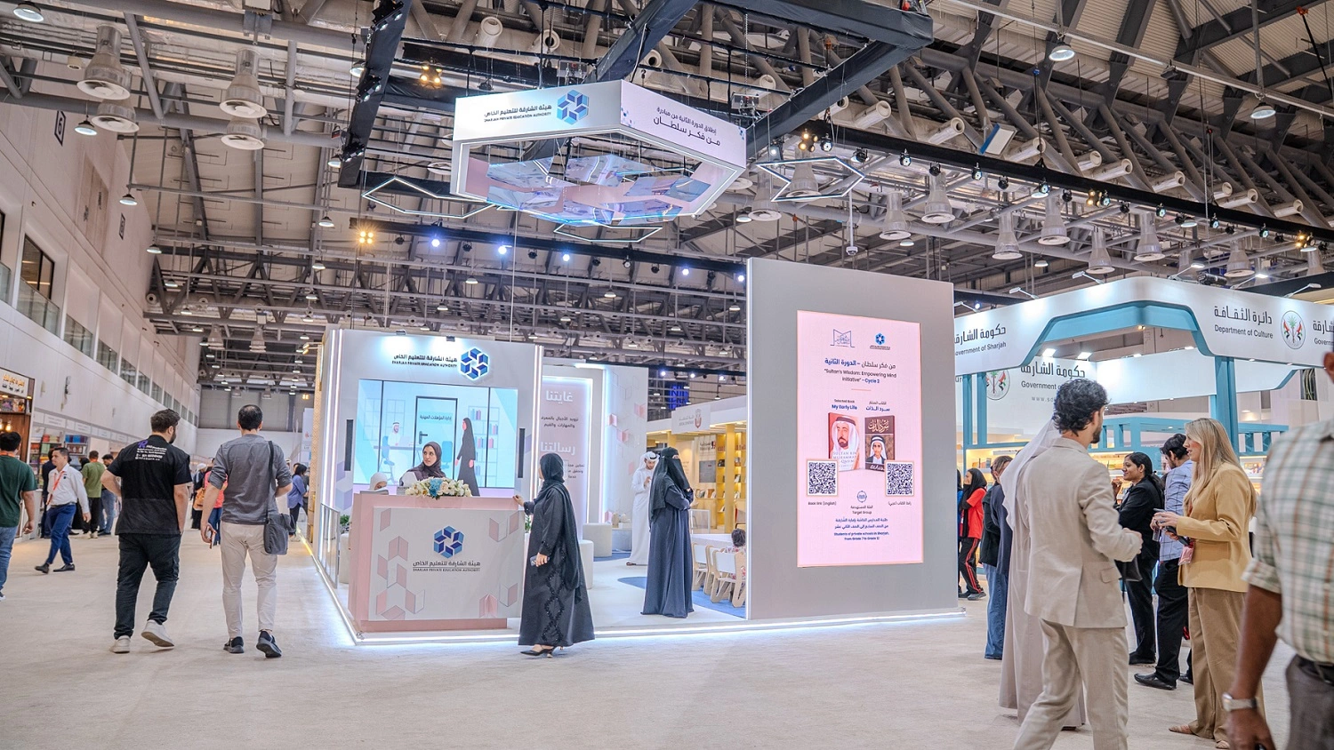 Visitors at the SPEA exhibition stand with illuminated hanging canopy and reception counter by Topaz Events, Sharjah