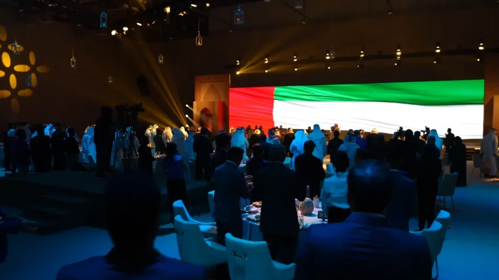 Guests standing for the national anthem with the UAE flag on the LED wall at the Sharjah Excellence Award 2023
