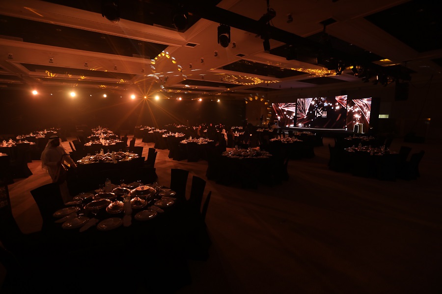 Ballroom banquet tables in warm light facing the LED stage at the Shukran Annual Ceremony 2024, Sharjah
