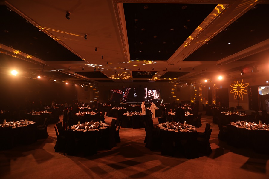 Black-and-gold ballroom with banquet tables and LED stage at the Shukran Annual Ceremony 2024 by Topaz Events