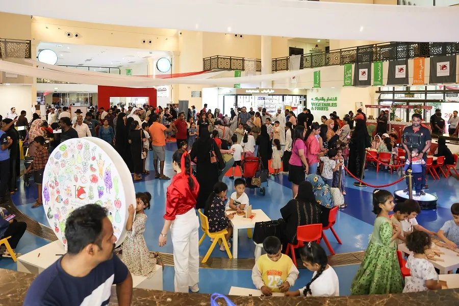 Families enjoying a prize wheel and craft activities inside Souq Al Jubail at the Sharjah Asset Management 15th Anniversary