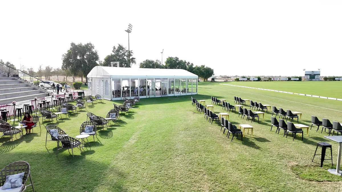 Luxury outdoor seating area featuring pink velvet furniture and elegant floral centerpieces by Topaz Events.
