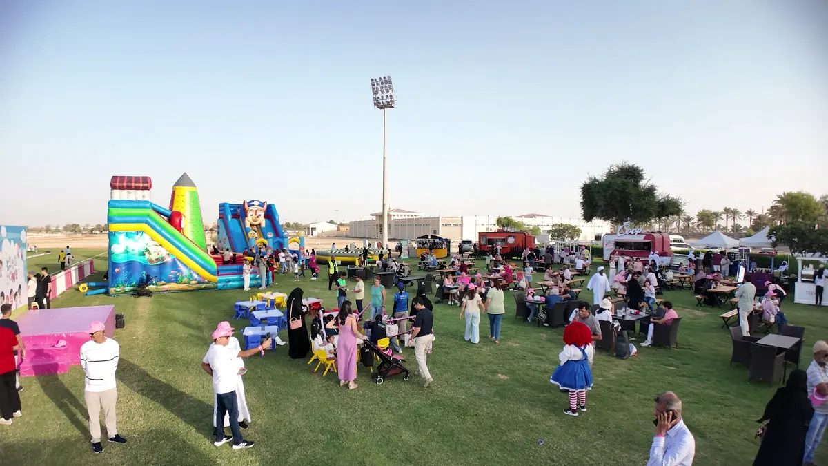 Diverse crowd of guests gathering at the Pink Polo 2025 event during the day, enjoying the outdoor hospitality and vibrant atmosphere at Ghantoot Racing & Polo Club.