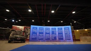 Custom event branding and directional signage integrated into the classic car museum's historic architecture.