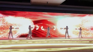 Interactive dance performance with synchronized digital visuals on background screens.