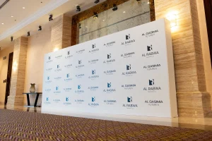 Branded media wall and elegant reception desk setup for corporate VIP guest arrival.