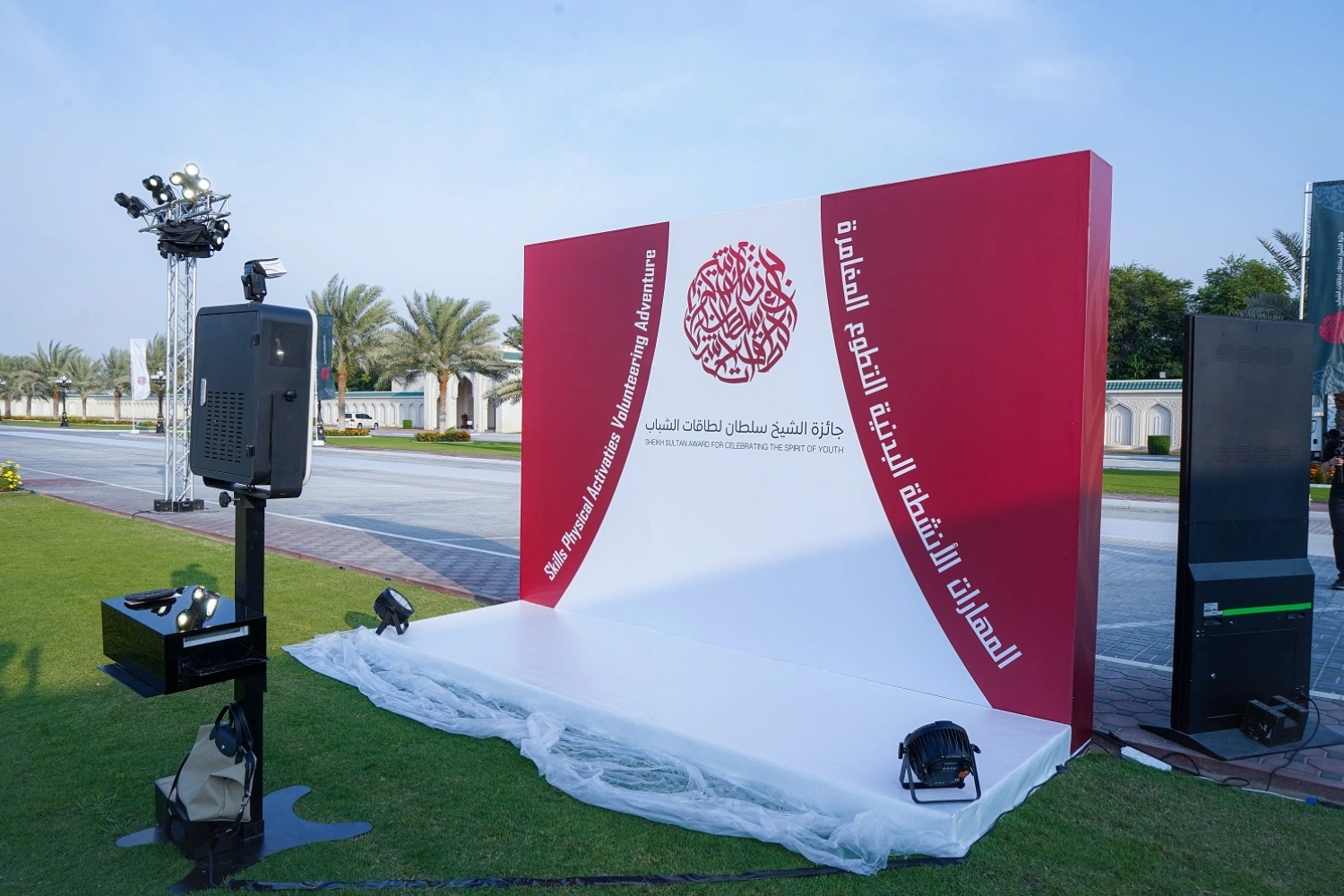 Custom-designed event photo wall by Topaz Events for the Sheikh Sultan Award. The premium branded backdrop is installed outdoors with integrated stage lighting and an interactive photo booth for guests.