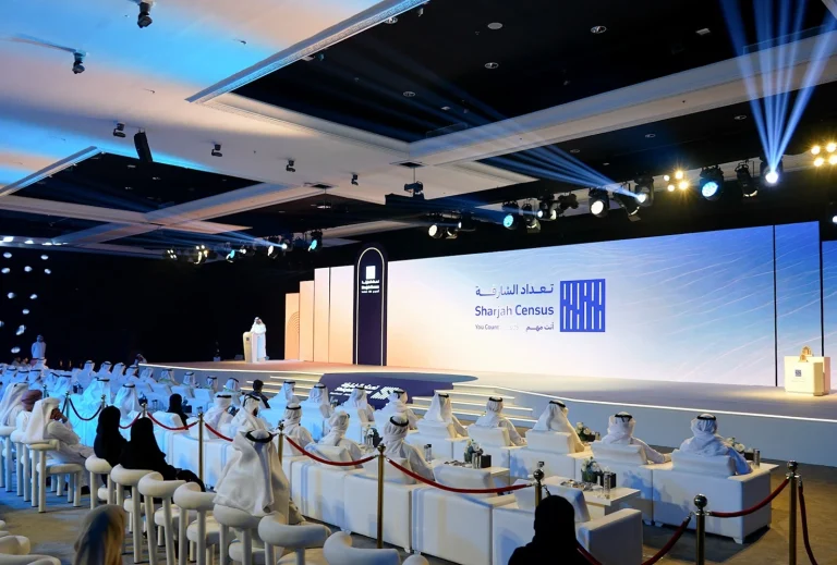 Large stage with LED screen and podium by Topaz Events for the 2025 Sharjah Census Reveal, with guests seated and attending the event at Al Jawaher Convention Centre, Sharjah