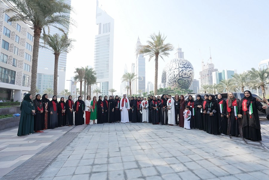 Dubai World Trade Centre women's team in abayas and UAE flag scarves at the 52nd UAE National Day celebration